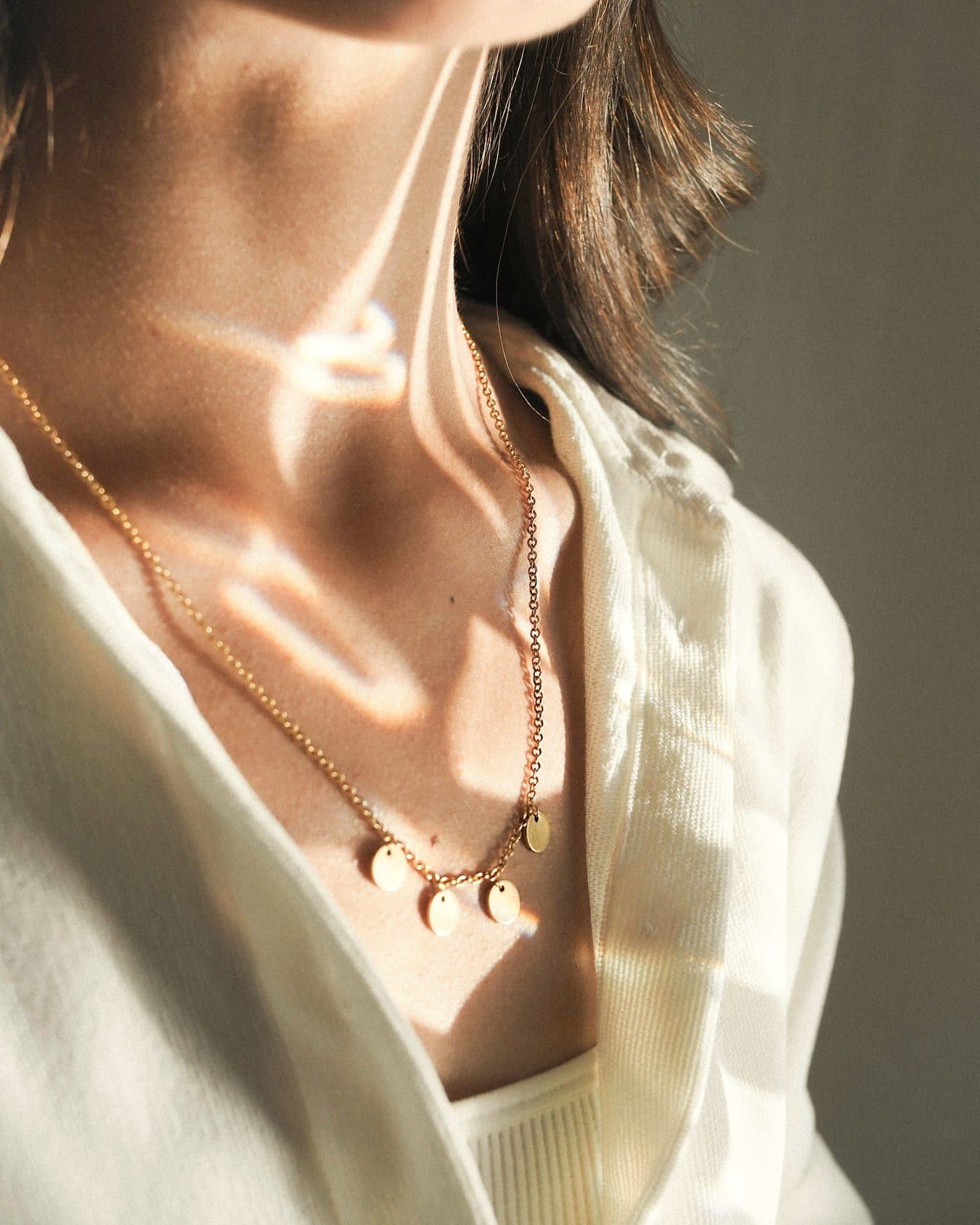 Mujer luciendo joyas doradas de la colección Luz de Caro Sáez