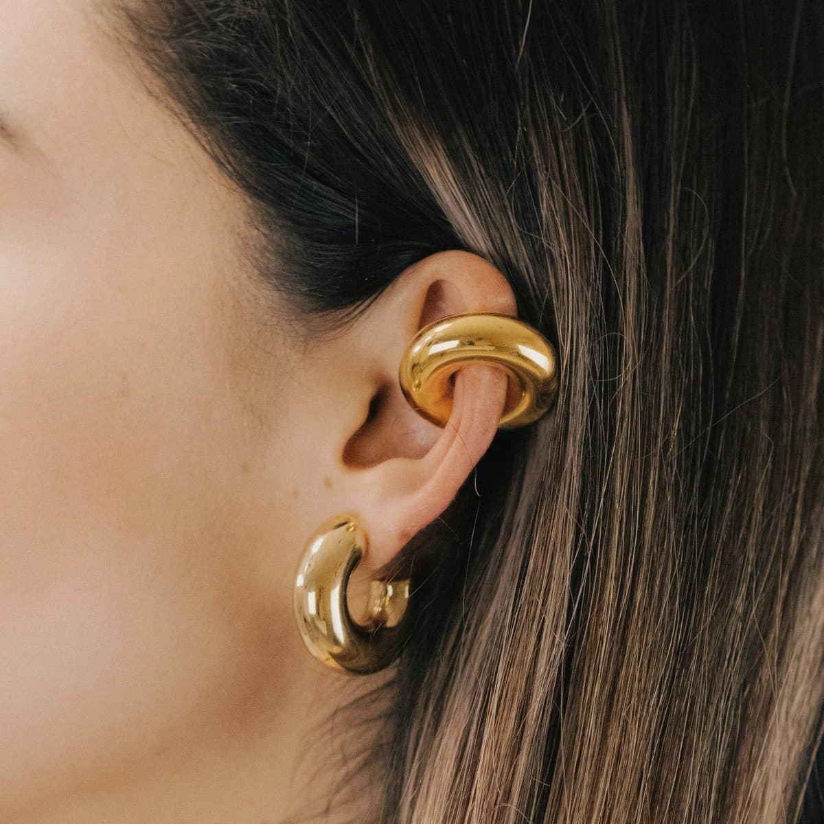 Argollas gruesas doradas y ear cuff en la oreja